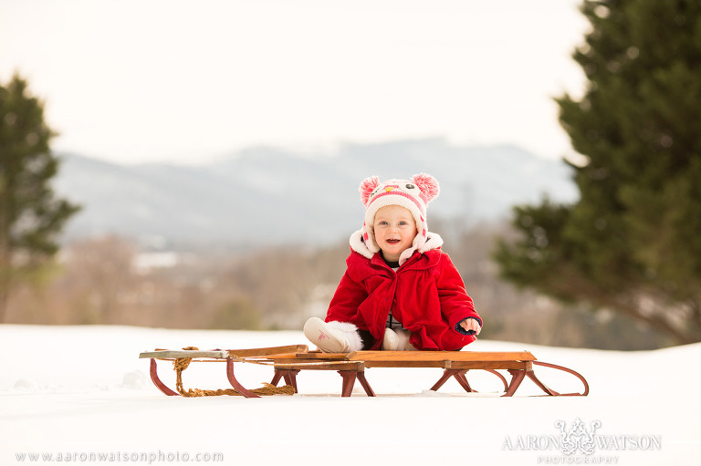 baby portrait with retro sled in snow