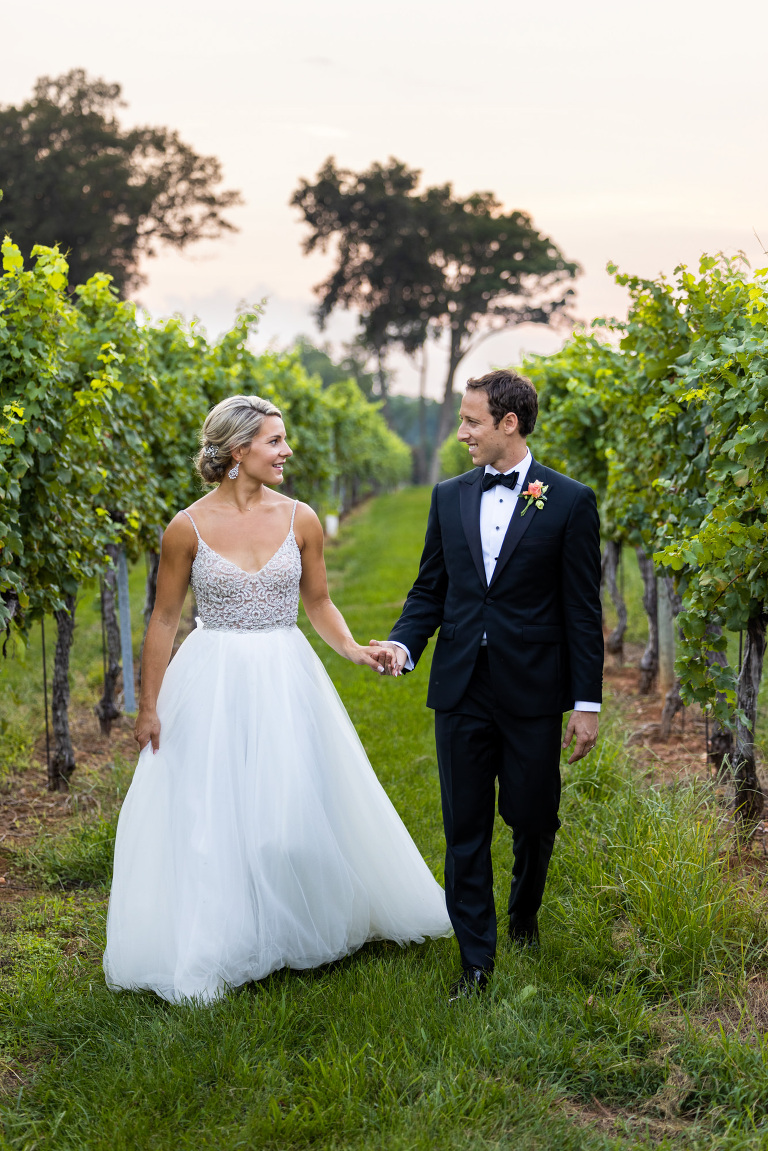 bride and groom walking in vineyard